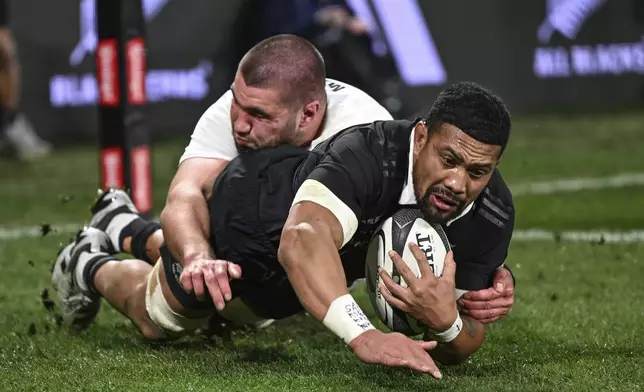 New Zealand's Ardie Savea, right, scores a try against England during their rugby union test match in Dunedin, New Zealand, Saturday July 6, 2024. (Steve McArthur/Photosport via AP)