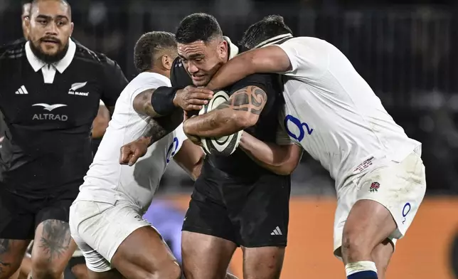 New Zealand's Codie Taylor, second right, is tackled by England defenders during their rugby union test match in Dunedin, New Zealand, Saturday July 6, 2024. (Andrew Cornaga/Photosport via AP)