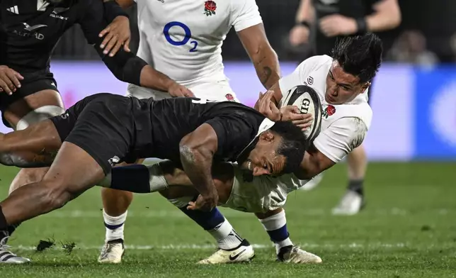 England's Marcus Smith, right, is tackled by New Zealand's Sevu Reece during their rugby union test match in Dunedin, New Zealand, Saturday July 6, 2024. (Andrew Cornaga/Photosport via AP)