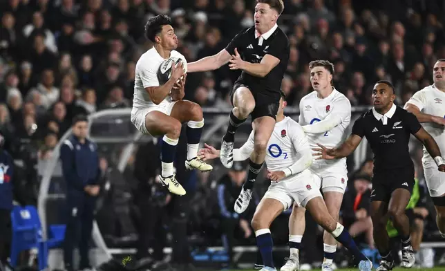 England's Marcus Smith, left, wins a high ball contest with New Zealand's Jordie Barrett during their rugby union test match in Auckland, New Zealand, Saturday, July 13, 2024. (Kerry Marshall/photosport via AP)