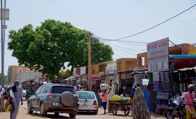 Pedestrian shops at a market in Niamey, Niger, Wednesday, July. 24, 2024. One year has passed since a dramatic coup in Niger. (AP Photo/Omar Hama)