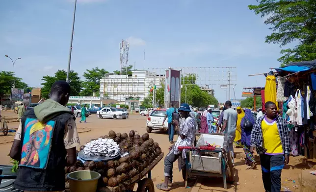 A man sells coconuts on the street in Niamey, Niger, Wednesday, July. 24, 2024. One year has passed since a dramatic coup in Niger. (AP Photo/Omar Hama)