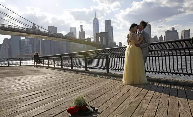 FILE - Nana Mu and Chase Che pose for their wedding photos in Brooklyn Bridge Park, June 30, 2016, in New York. (AP Photo/Kathy Willens, File)