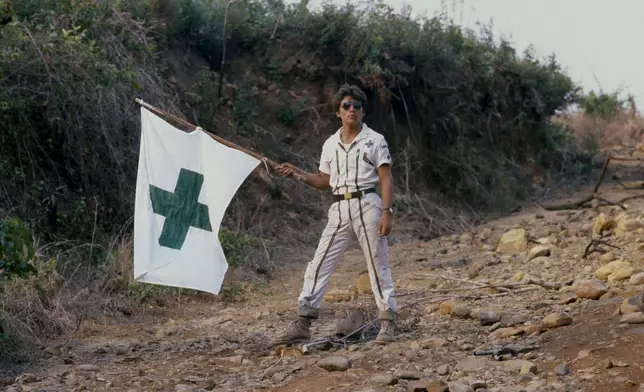 FILE - A Salvadoran Green Cross medical worker waves a white flag in El Salvador, April 19, 1981. (AP Photo/Kathy Willens, File)