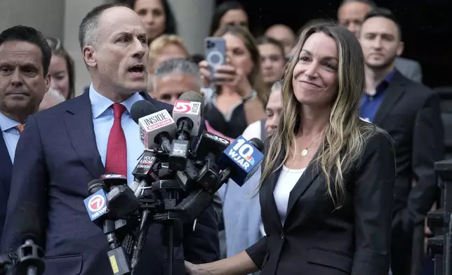Karen Read, right, smiles as defense attorney David Yannetti, front left, speaks to reporters in front of Norfolk Superior Court after the judge declared a mistrial after jurors were unable to reach a verdict following a two-month trial, Monday, July 1, 2024, in Dedham, Mass. (AP Photo/Steven Senne)