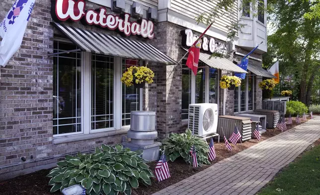 FILE - Flags fly outside the Waterfall Bar &amp; Grille, Thursday, June 27, 2024, in Canton, Mass. Video evidence presented in the trial of Karen Read, showed the Waterfall as the last place where Read and her boyfriend John O'Keefe were seen together in public. A judge declared a mistrial Monday, July 1, 2024, after jurors deadlocked in the case of Read, who was accused of killing her police officer boyfriend, O'Keefe, by striking him with her SUV and leaving him in a snowstorm. (AP Photo/Charles Krupa, File)