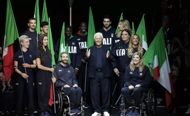 FILE - Designer Giorgio Armani accepts applause with Italy's Paralympic team at the end of the Emporio Armani men's Spring Summer 2024 collection presented in Milan, Italy, Saturday, June 17, 2023. Italian athletes will be elegantly attired in Emporio Armani uniforms, as they have for every Olympics since 2012. (AP Photo/Luca Bruno, File)