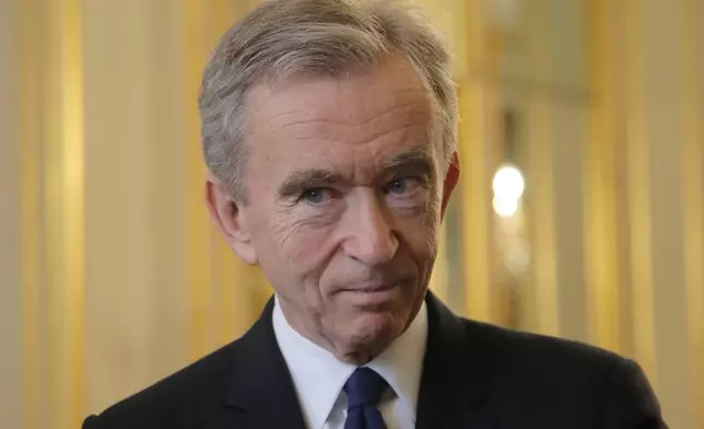 FILE - CEO of LVMH Bernard Arnault listens at the global tech conference Viva Technology at the Elysee Palace in Paris, Tuesday, Feb. 21, 2017. With a major sponsorship role aimed at burnishing the image of the Paris 2024 Summer Olympic Games and the French capital, it's a new chapter in LVMH's specialty of selling exclusivity at a grand scale under its chair and CEO, Arnault. (AP Photo/Michel Euler, Pool, File)