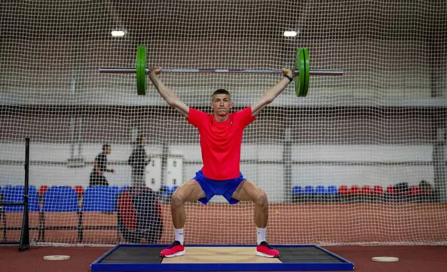 High jumper Oleh Doroshchuk lifts weights during a training session at a regional youth sport school for the Olympics, in Kropyvnytskyi, Ukraine, Thursday, April 18, 2024. (AP Photo/Francisco Seco)