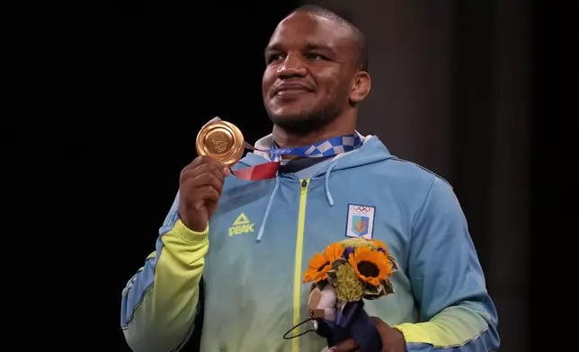 FILE - Gold medalist, Zhan Beleniuk of Ukraine, celebrates on the podium during the medal ceremony for the men's 87kg Greco-Roman wrestling at the 2020 Summer Olympics, Wednesday, Aug. 4, 2021, in Chiba, Japan. An Associated Press analysis found Russia's war is making it increasingly difficult for Ukraine, once a post-Soviet sports power, to get those headline-capturing medals. Ukrainian performances began dipping after 2014, the year of Russia's illegal annexation of Crimea. (AP Photo/Aaron Favila, File)