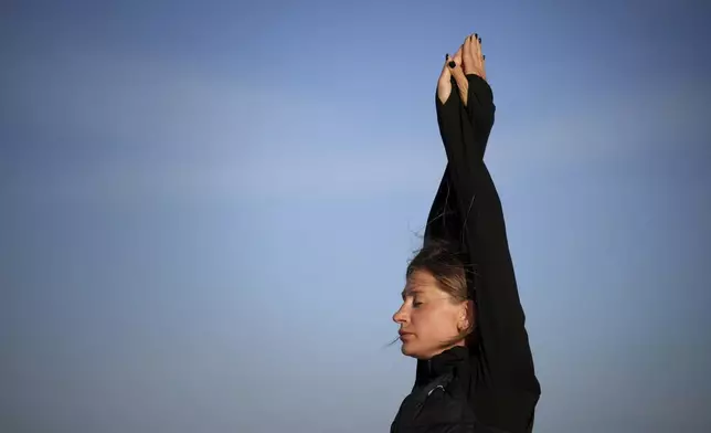 Ukrainian high jumper Kateryna Tabashnyk warms up on a beach in Monte Gordo, Portugal, Tuesday, May 7, 2024. Focus and drive is a requirement for all high-level athletes. But the 30-year-old’s mind wanders often to her bombarded native city of Kharkiv and the Russian missiles that have stolen so much: her mother, her apartment, a pain-free childhood for her nephew, even the fields where she trained. (AP Photo/Emilio Morenatti)