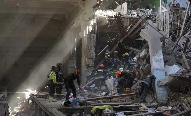 Rescue workers clear rubble on Aug. 18, 2022, at the home of Kateryna Tabaschnyk's mother, who was killed in a Russian Rocket attack in Kharkiv. (AP Photo/Andrii Marienko)