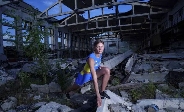 Kateryna Tabashnyk, a high jumper, poses for a portrait Sunday, June 9, 2024, at the athletics arena of the "Polytechnic" sports complex, which was destroyed by a Russian rocket attack, in Kharkiv, Ukraine. (AP Photo/Evgeniy Maloletka)