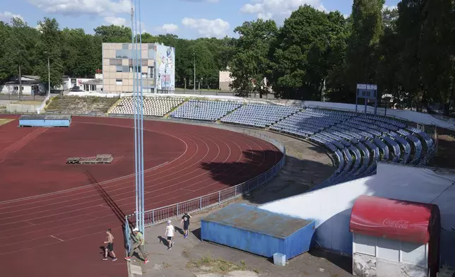 Children walk through Dynamo Stadium in Kharkiv, Ukraine, Friday, June 7, 2024. (AP Photo/Evgeniy Maloletka)