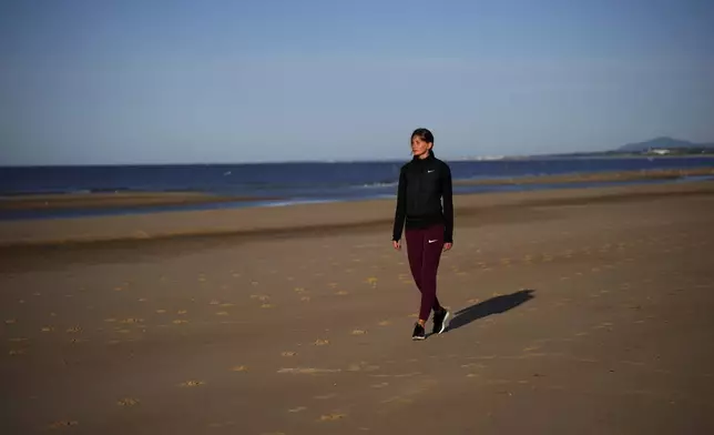 Ukrainian high jumper Kateryna Tabashnyk walks along a beach in Monte Gordo, Portugal, Tuesday, May 7, 2024. (AP Photo/Emilio Morenatti)