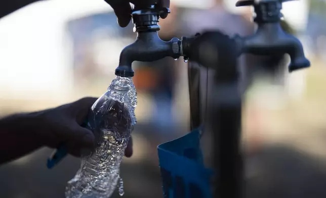 FILE - A person fills their water bottle while attending the Waterfront Blues Festival, July 5, 2024, in Portland, Ore. Record daily high temperatures in Oregon were suspected in four deaths reported in the Portland area Monday, July 8, as much of the country continued to swelter under an early heat wave. (AP Photo/Jenny Kane, File)