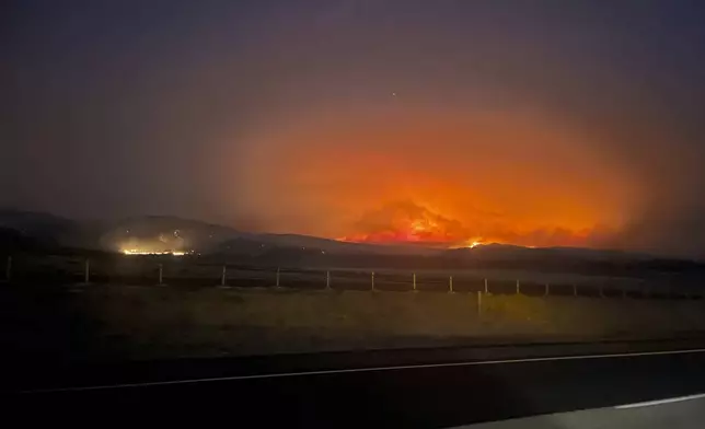 In this image provided by the Oregon Department of Transportation, the Durkee fire burns in the background as it nears Interstate 84 near Huntington, Ore., early Tuesday, July 23, 2024. (Oregon Department of Transportation via AP)