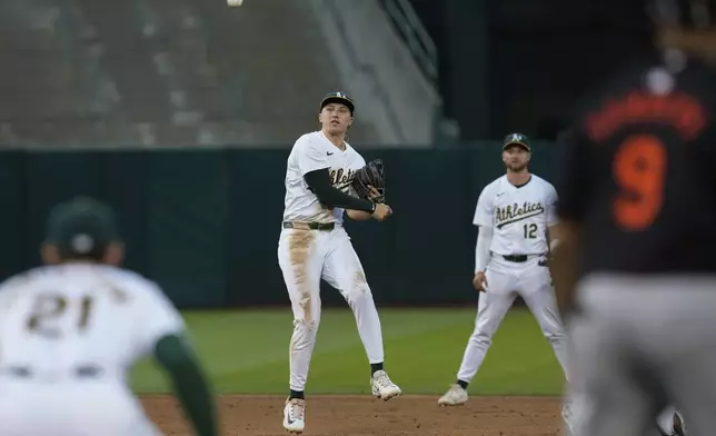 Oakland Athletics second baseman Zack Gelof, center, throws to first baseman Tyler Soderstrom, foreground left, after forcing out Baltimore Orioles' Austin Hays at second during the sixth inning of a baseball game Friday, July 5, 2024, in Oakland, Calif. Colton Cowser reached first in the play. (AP Photo/Godofredo A. Vásquez)