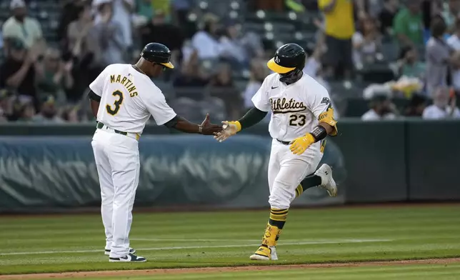 Oakland Athletics' Shea Langeliers, right, celebrates with third base coach Eric Martins, left, after hitting a solo home run against the Baltimore Orioles during the seventh inning of a baseball game Friday, July 5, 2024, in Oakland, Calif. (AP Photo/Godofredo A. Vásquez)