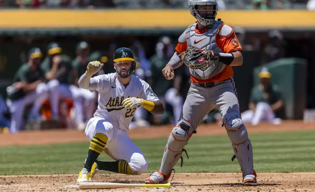 Oakland Athletics' Miguel Andujar (22) scores behind Baltimore Orioles catcher Adley Rutschman during the second inning of a baseball game Saturday, July 6, 2024, in Oakland, Calif. (AP Photo/John Hefti)