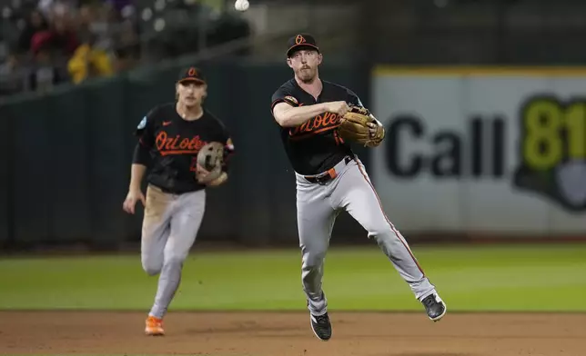 Baltimore Orioles third baseman Jordan Westburg, right, throws out Oakland Athletics' Brent Rooker at first during the eighth inning of a baseball game Friday, July 5, 2024, in Oakland, Calif. (AP Photo/Godofredo A. Vásquez)