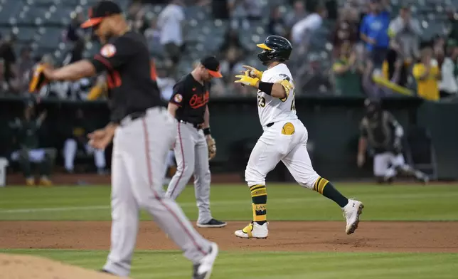 Oakland Athletics' Shea Langeliers, right, runs the bases after hitting a solo home run against Baltimore Orioles pitcher Albert Suárez, foreground left, during the seventh inning of a baseball game Friday, July 5, 2024, in Oakland, Calif. (AP Photo/Godofredo A. Vásquez)