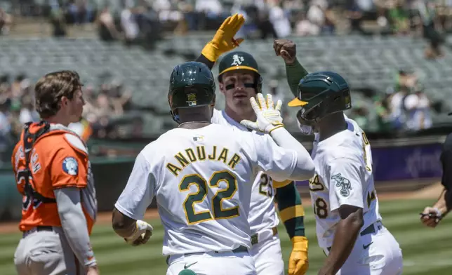 Oakland Athletics' Brent Rooker, center, is congratulated by Miguel Andujar (22) and Daz Cameron after hitting a three-run home-run against the Baltimore Orioles during the first inning of a baseball game Saturday, July 6, 2024, in Oakland, Calif. (AP Photo/John Hefti)