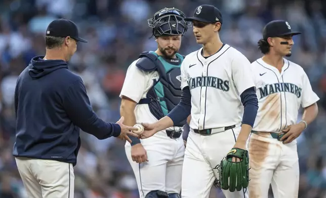 Seattle Mariners starting pitcher George Kirby, second from right, is pulled from a baseball game against the Baltimore Orioles in the seventh inning by manager Scott Servais during a meeting at the mound with catcher Cal Raleigh, second from left, and third baseman Josh Rojas, Tuesday, July 2, 2024, in Seattle. (AP Photo/Stephen Brashear)
