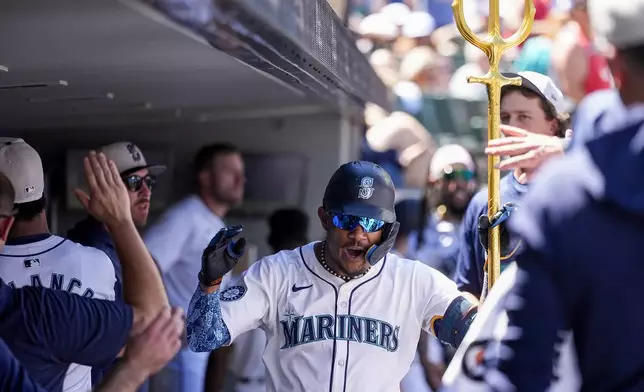 Seattle Mariners' Julio Rodríguez holds a trident in the dugout after his solo home run against the Baltimore Orioles during the fifth inning of a baseball game Thursday, July 4, 2024, in Seattle. (AP Photo/Lindsey Wasson)