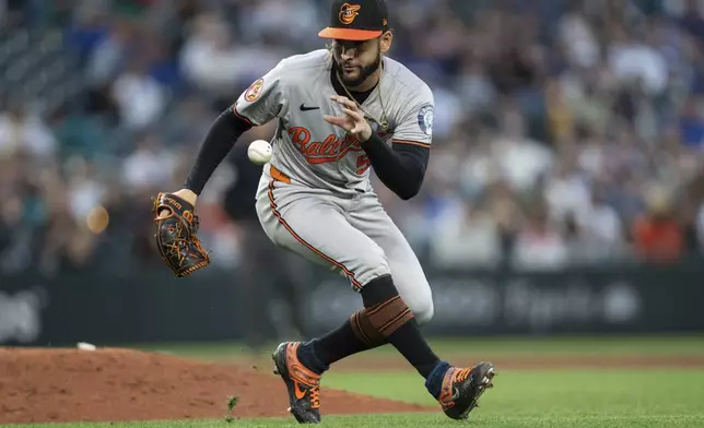 Baltimore Orioles relief pitcher Cionel Perez fields a ground ball barehanded during the eighth inning during the eighth inning of a baseball game against the Seattle Mariners, Tuesday, July 2, 2024, in Seattle. (AP Photo/Stephen Brashear)
