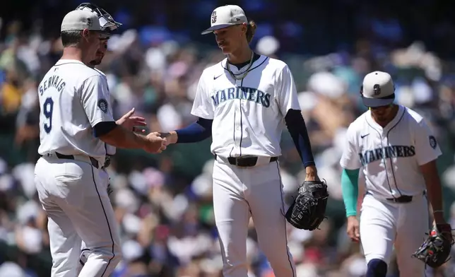 Seattle Mariners manager Scott Servais (9) arrives on the mound to pull starting pitcher Bryce Miller, center, against the Baltimore Orioles during the sixth inning of a baseball game Thursday, July 4, 2024, in Seattle. (AP Photo/Lindsey Wasson)
