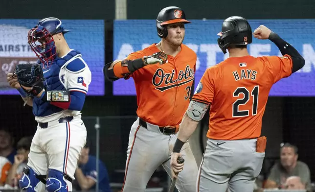 Baltimore Orioles' Ryan O'Hearn, left, is congratulated by Austin Hays (21) after hitting a solo home run off of Texas Rangers relief pitcher Jose Leclerc during the ninth inning of a baseball game Saturday, July 20, 2024, in Arlington, Texas. (AP Photo/Jeffrey McWhorter)