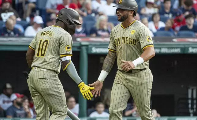 San Diego Padres' Jurickson Profar (10) greets David Peralta, right, after Peralta scored against the Cleveland Guardians during the fourth inning of a baseball game in Cleveland, Saturday, July 20, 2024. (AP Photo/Phil Long)