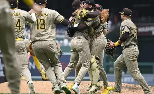 San Diego Padres team member rush onto the field to join in the celebration for Padres starting pitcher Dylan Cease, center, for his no-hitter after nine complete innings of a baseball game against the Washington Nationals, Thursday, July 25, 2024, in Washington. (AP Photo/John McDonnell)