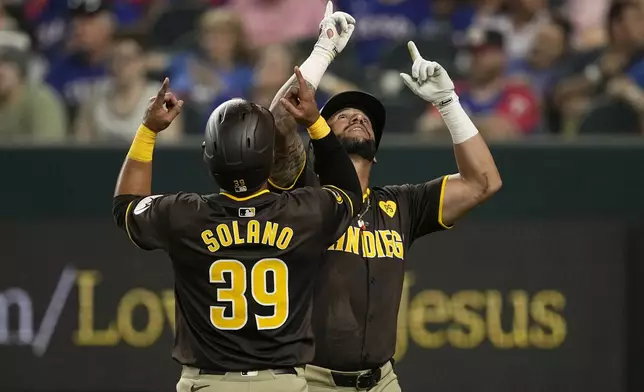 San Diego Padres' Donovan Solano (39) and David Peralta, right, celebrate Peralta's two-run home run that also scored Solano in the seventh inning of a baseball game against the Texas Rangers Wednesday, July 3, 2024 in Arlington, Texas. (AP Photo/Tony Gutierrez)