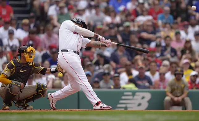 Boston Red Sox's Rafael Devers, right, hits a two-run home run off a pitch by San Diego Padres' Matt Waldron as Padres catcher Kyle Higashioka, left, looks on in the first inning of a baseball game, Sunday, June 30, 2024, in Boston. (AP Photo/Steven Senne)