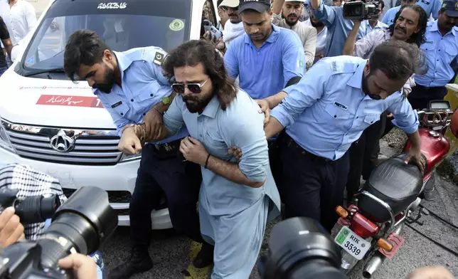 Security personnel detain Supporters of the Pakistani religious group "Jamaat-e-Islami" during a protest against the price hike and additional taxes and increasing electricity and gas tariffs, in Islamabad, Pakistan, Friday, July 26, 2024. (AP Photo/W.K. Yousafzai)