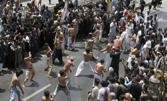 Shiite Muslims flagellate themselves with knifes attached to chains during a Muharram procession, in Peshawar, Pakistan, Tuesday, July 16, 2024. Muharram, the first month of the Islamic calendar, is a month of mourning for Shiites in remembrance of the death of Hussein, the grandson of the Prophet Muhammad, at the Battle of Karbala in present-day Iraq in the 7th century. (AP Photo/Muhammad Sajjad)