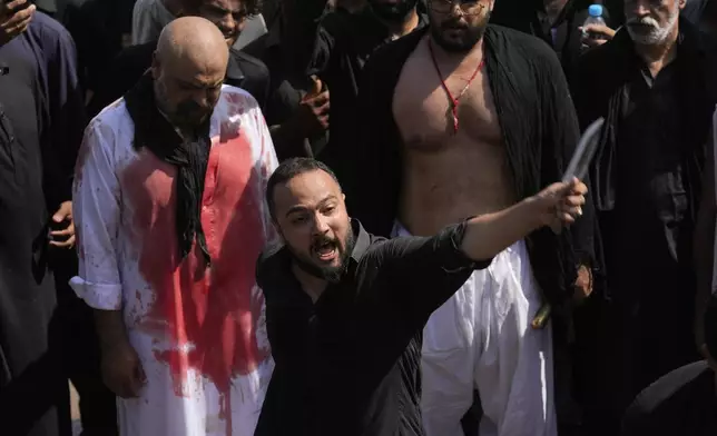 A Shiite Muslim flagellates himself with knife during a Muharram procession, in Islamabad, Pakistan, Tuesday, July 16, 2024. Muharram, the first month of the Islamic calendar, is a month of mourning for Shiites in remembrance of the death of Hussein, the grandson of the Prophet Muhammad, at the Battle of Karbala in present-day Iraq in the 7th century. (AP Photo/Anjum Naveed)