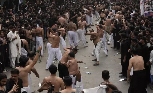 Shiite Muslims flagellate themselves with knifes attached to chains during the battle of Karbala, during a Muharram procession, in Lahore, Pakistan, Tuesday, July 16, 2024. Muharram, the first month of the Islamic calendar, is a month of mourning for Shiites in remembrance of the death of Hussein, the grandson of the Prophet Muhammad, at the Battle of Karbala in present-day Iraq in the 7th century. (AP Photo/K.M. Chaudary)