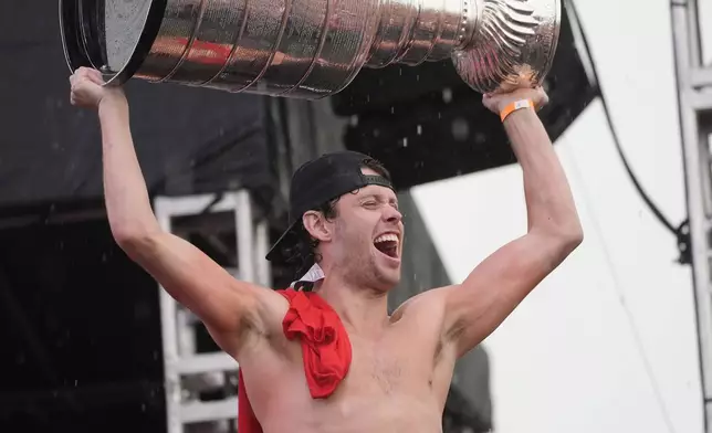 Florida Panthers' Carter Verhaeghe raises the Stanley Cup during an NHL hockey parade and rally, Sunday, June 30, 2024, in Fort Lauderdale, Fla. Verhaeghe scored the winning goal to defeat the Edmonton Oilers to win the cup. (AP Photo/Marta Lavandier)