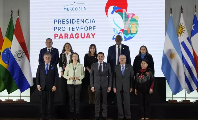 Foreign ministers, front row, and staff pose for a photo ahead of a Mercosur summit at the Port building in Asuncion, Paraguay, Sunday, July 7, 2024. From left are Uruguay's Omar Paganini, Argentina's Diana Mondino, Paraguay's Ruben Ramirez, Brazil's Mauro Vieira and Bolivia's Celinda Sosa. (AP Photo/Jorge Saenz)