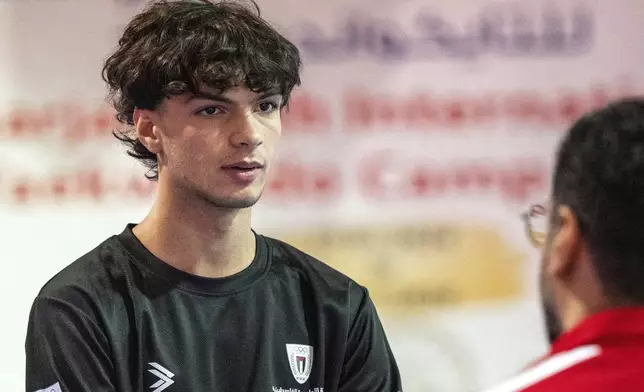 Omar Ismail, who was born in Dubai and will be competing for the Palestinian territories at the Paris Olympics, talks to his taekwondo coach in Sharjah, United Arab Emirates, on Thursday, June 20, 2024. (AP Photo/Martin Dokoupil)