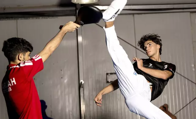 Omar Ismail, who was born in Dubai and will be competing for the Palestinian territories at the Paris Olympics, practices taekwondo in Sharjah, United Arab Emirates, on Thursday, June 20, 2024. (AP Photo/Martin Dokoupil)