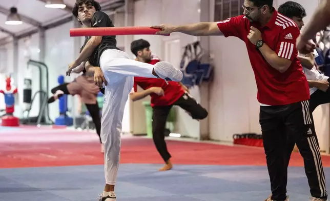Omar Ismail, who was born in Dubai and will be competing for the Palestinian territories at the Paris Olympics, practices taekwondo in Sharjah, United Arab Emirates, on Thursday, June 20, 2024. (AP Photo/Martin Dokoupil)