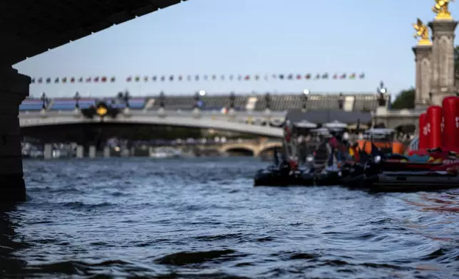 The Seine River flows in front of the Pont Alexandre III bridge, site of the triathlon events at the 2024 Summer Olympics, Monday, July 29, 2024, in Paris. As the Olympics continue in Paris, the Seine River's water quality remains a major area of concern for officials. Organizers of the triathlon event cancelled swimming practice on Monday for the second day in a row because of poor water quality. Event organizers hope sunny weather will make swimming viable on Tuesday when the triathlon begins. (AP Photo/David Goldman)