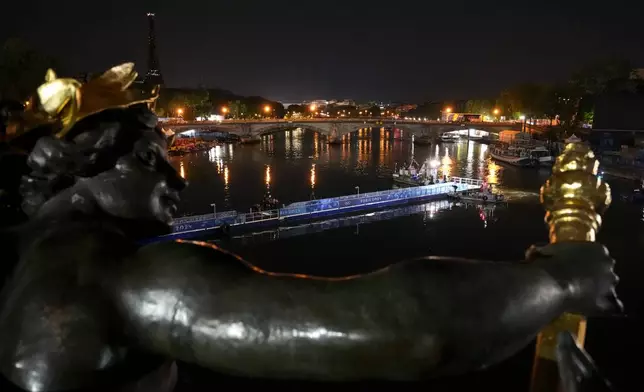 Technicians remove the pontoon for the start of the triathlon events after the event was postponed over concerns about water quality in Paris' Seine River, at the 2024 Summer Olympics, Tuesday, July 30, 2024, at the Pont Alexandre III bridge in Paris, France. (AP Photo/Yasin Dar)