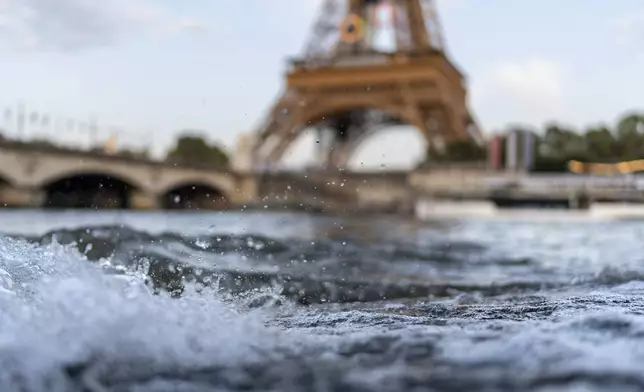 Waves crash along the banks of the Seine River in front of the Eiffel Tower during the 2024 Summer Olympics, Monday, July 29, 2024, in Paris. As the Olympics continue in Paris, the Seine River's water quality remains a major area of concern for officials. Organizers of the triathlon event cancelled swimming practice on Monday for the second day in a row because of poor water quality. Event organizers hope sunny weather will make swimming viable on Tuesday when the triathlon begins. (AP Photo/David Goldman)