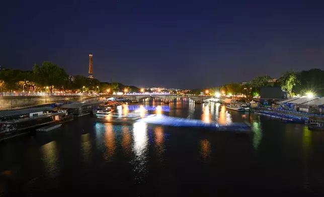 Technicians remove the pontoon for the start of the triathlon events after the event was postponed over concerns about water quality in Paris' Seine River, at the 2024 Summer Olympics, Tuesday, July 30, 2024, at the Pont Alexandre III bridge in Paris, France. (AP Photo/Vadim Ghirda)