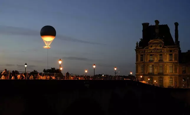 The Olympic cauldron beams at sunset in the Tuileries Garden during the 2024 Summer Olympics, Monday, July 29, 2024, in Paris, France. (AP Photo/Natacha Pisarenko)